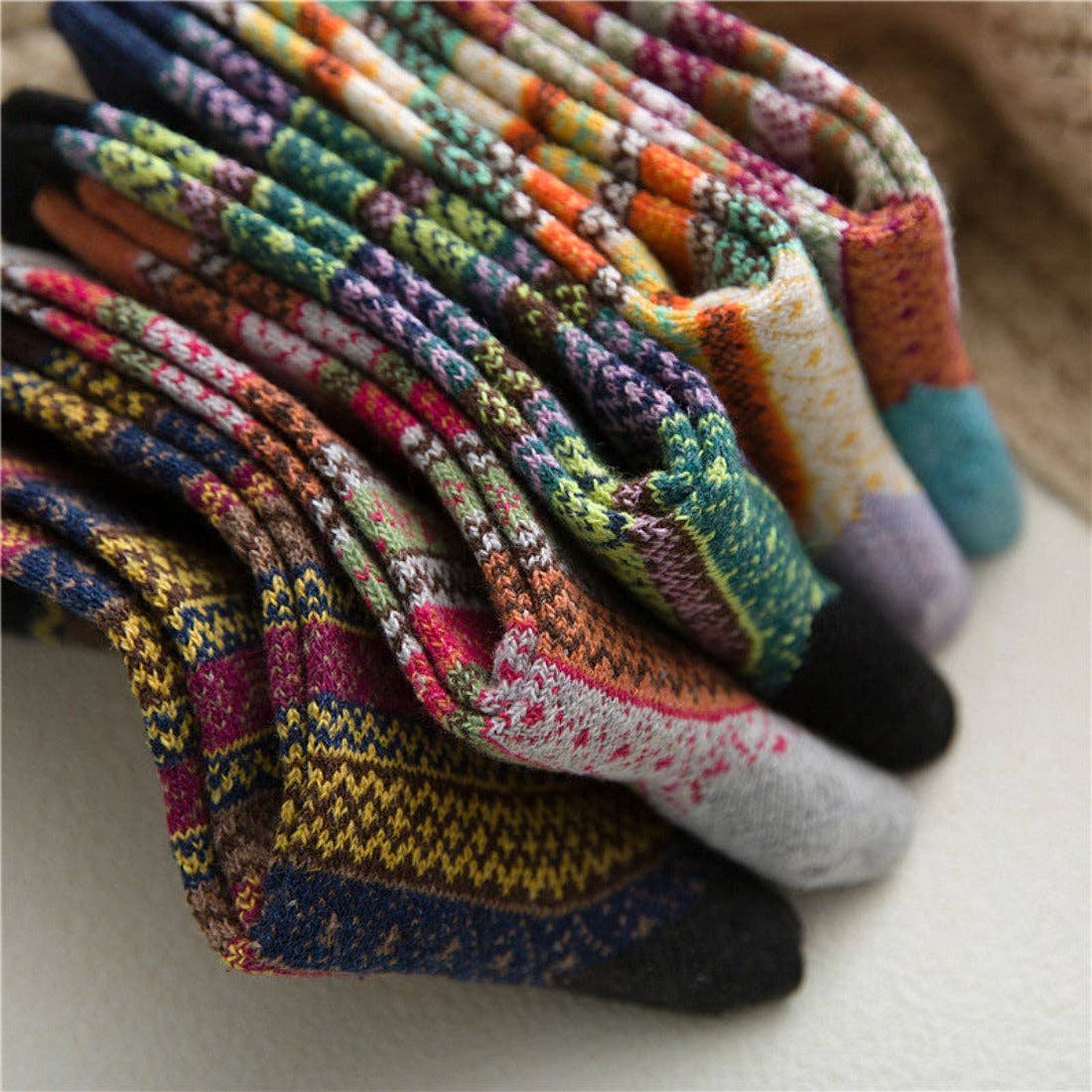 Stack of colorful patterned socks on a light surface