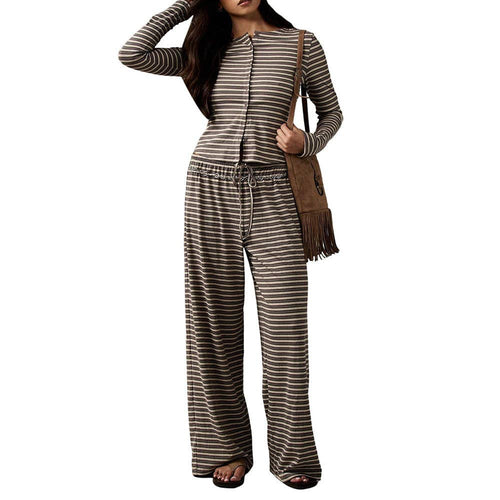 Woman wearing a striped jumpsuit holding a brown bag on a white background