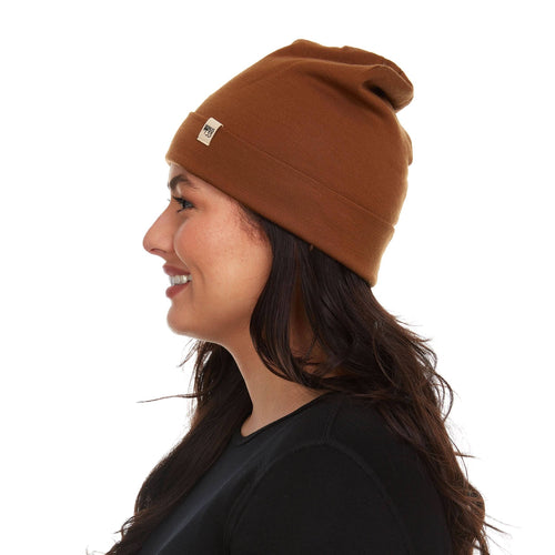 Woman wearing a brown beanie on a white background