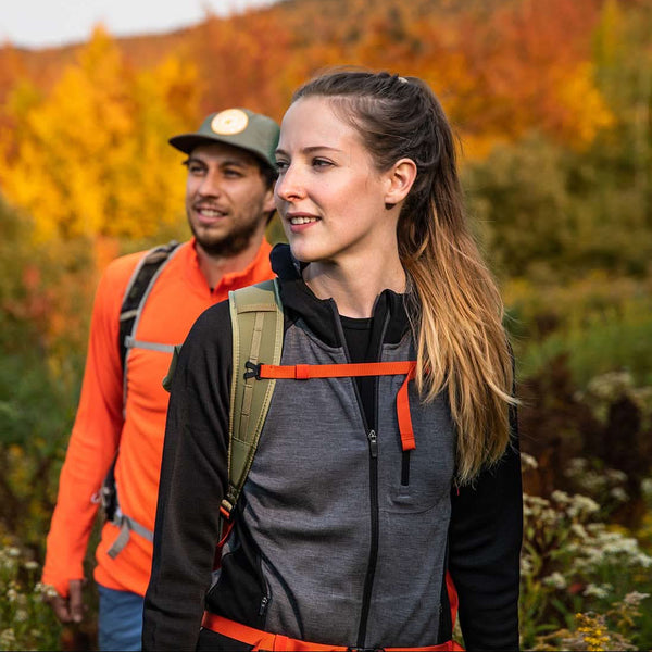Two hikers in a forest with autumn foliage