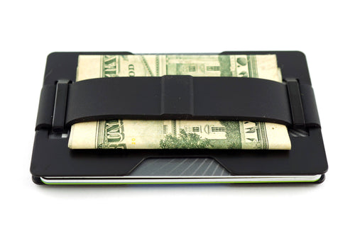 A black slim card holder wallet with a built-in money clip holding a folded one hundred dollar bill, shown on a plain white background.