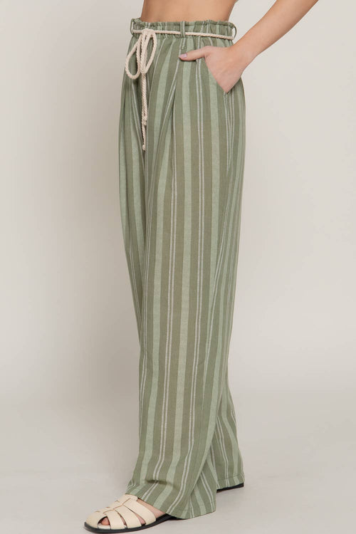 Person wearing green striped pants with a plain background