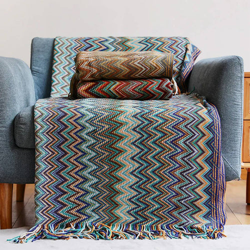 Colorful zigzag patterned blanket draped over a gray armchair.