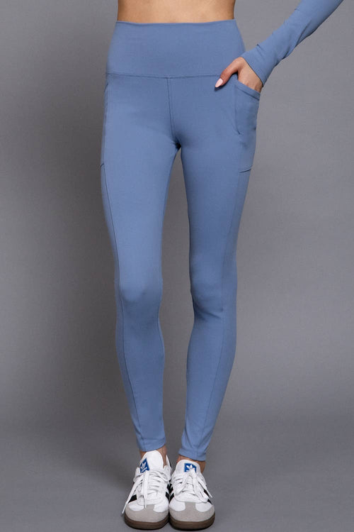 Blue leggings worn by a person on a gray background