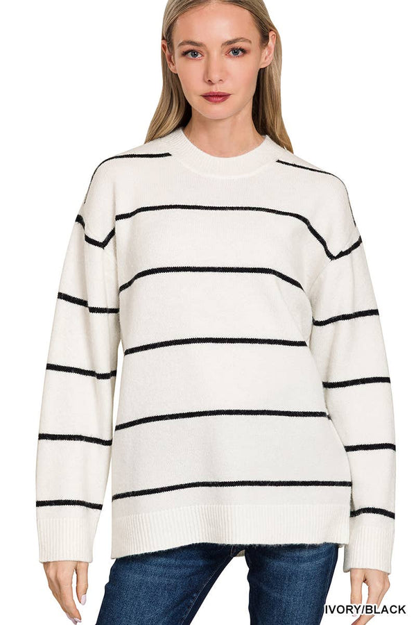 Woman wearing a white sweater with black stripes on a plain background