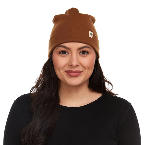 Woman wearing a brown beanie with a logo on a white background