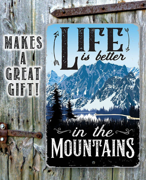 Decorative sign with mountain landscape and 'Life is better in the Mountains' text on a wooden background.