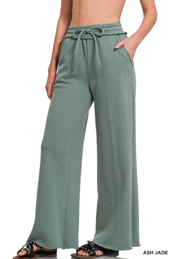 Green wide-leg pants worn by a person on a white background