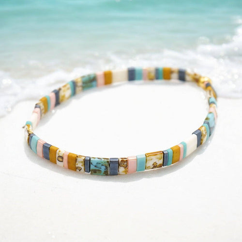 Multicolored beaded bracelet on a blurred beach background