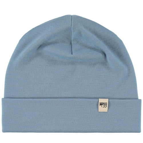 A  blue knit beanie hat with a folded cuff and a small square brand patch on the front, shown against a plain white background.