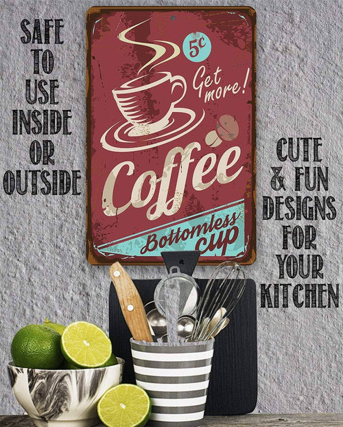 A decorative rectangular metal sign with a distressed coffee-themed design hangs on a gray wall above a kitchen utensil holder. The sign is reddish brown with cream lettering reading 'Coffee' and 'Get more!', plus a cup illustration and small coffee beans.