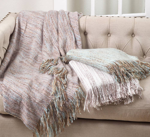 Two textured throw blankets on a beige sofa with a neutral background