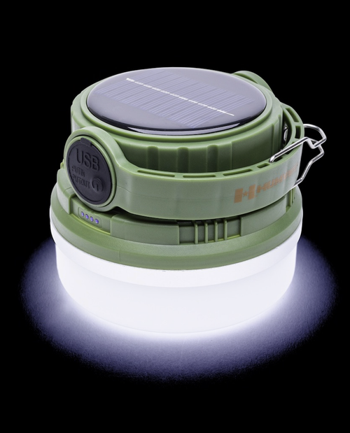 Green camping lantern with solar panel on a black background