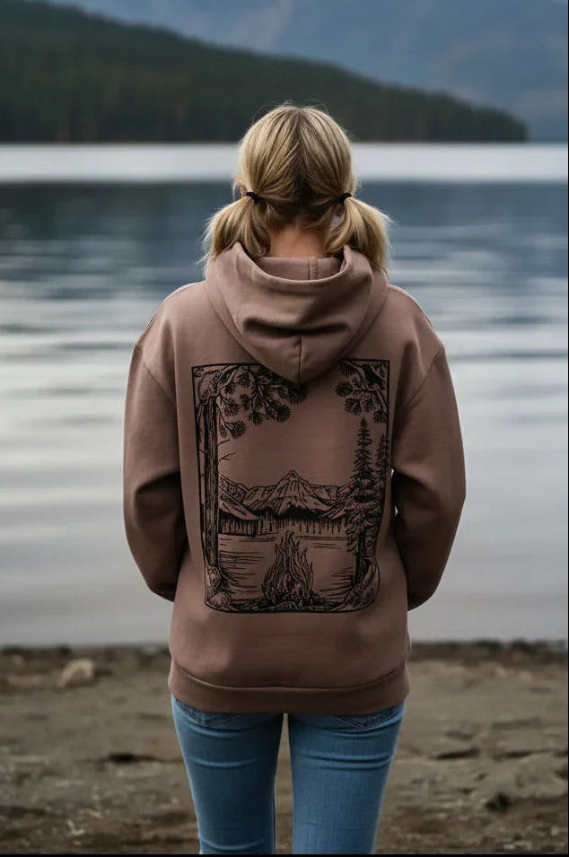 Woman in nature hoodie with mountain lake print, standing by Lake