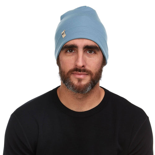 Man wearing a light blue beanie with a logo on a white background