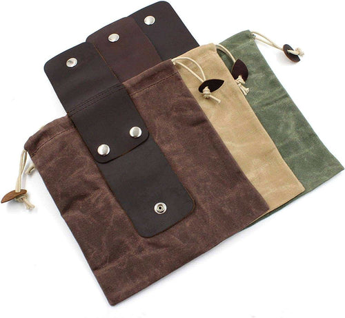 Waxed canvas drawstring bags with leather accents in brown, tan, and green, featuring metal snap closures.