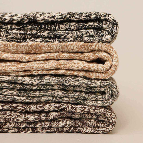 Stack of folded textured socks on a neutral background