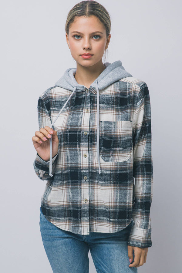 Hooded Flannel Shirt A woman modeling a hooded button-up shirt with a blue, gray, and white plaid pattern, featuring a light gray hood and drawstrings, paired with blue jeans.