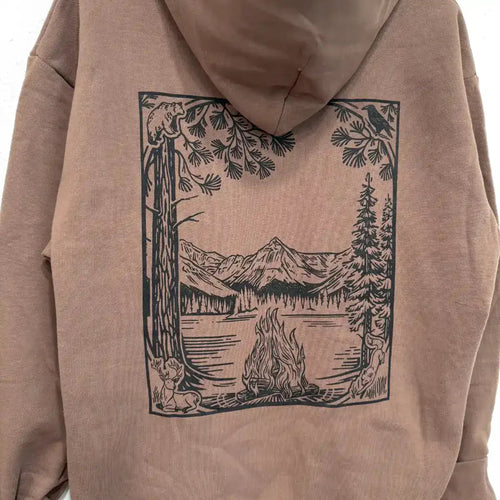 Oversized Pullover Hoodies Tan hoodie with forest scene print: campfire, mountains, lake, deer, bear, raven, pine trees