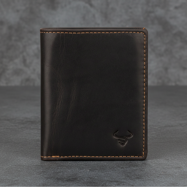 A dark brown leather bifold wallet with light tan contrast stitching and an embossed bull logo in the bottom right corner, set against a textured gray background.
