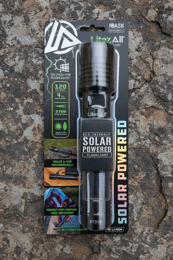 Solar-powered flashlight in packaging on a rocky surface