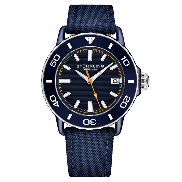 A Stuhrling Original analog watch with a dark blue dial, a matching blue rotating bezel with white markings, a silver-tone stainless steel case, and a textured navy blue fabric strap.