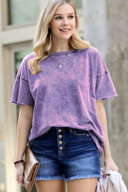 Woman wearing purple tie-dye oversized t-shirt with denim shorts, casual summer outfit