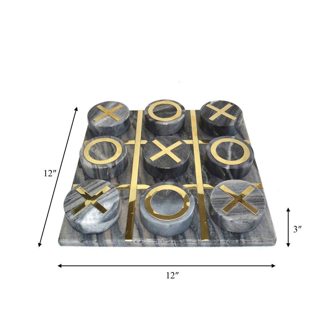 A square marble-look tic-tac-toe game board with round gray and black stone pieces featuring gold-colored 'X' and 'O' cutouts, shown with dimension arrows indicating 12 by 12 inches by 3 by 3 inches on a white background.