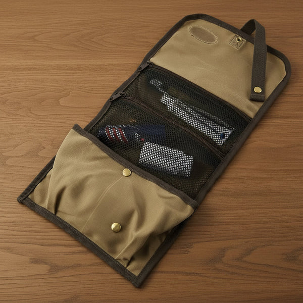 Tan and gray travel organizer with mesh pockets holding toiletries on wooden surface