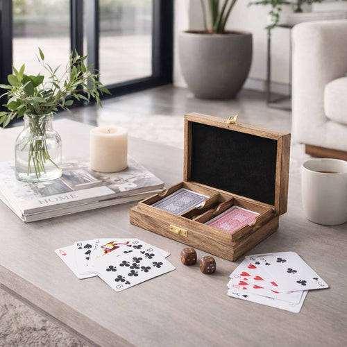 Wooden playing card set with cards and dice on a table in a living room setting.