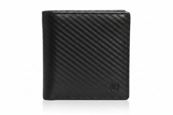 A black leather bifold wallet with a textured diagonal carbon-fiber-like pattern and a small debossed 'AD' logo in the bottom right corner, shown on a white background with a soft reflection.