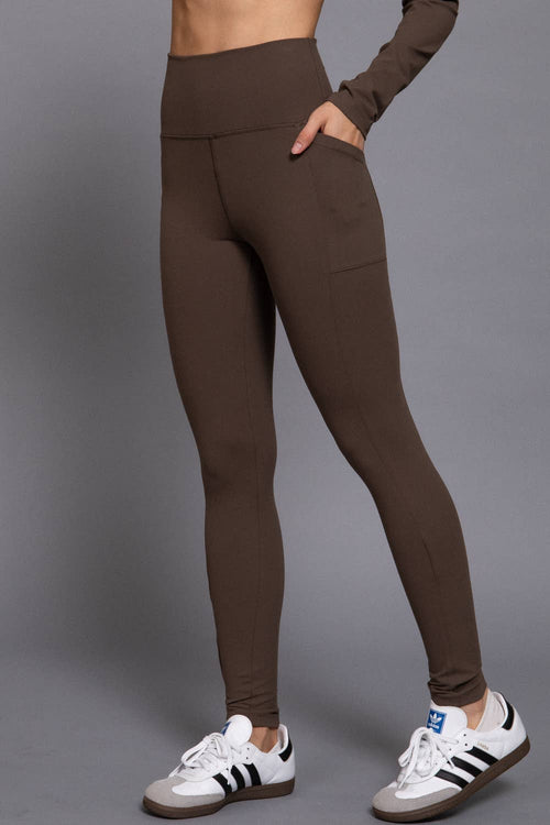 Brown leggings worn by a person on a gray background