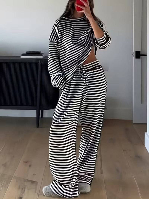 Person wearing a black and white striped outfit in a room with wooden flooring.