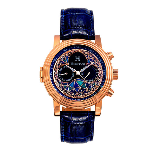 A luxury wristwatch with a rose gold case, a blue alligator leather strap, and a highly detailed blue and black dial featuring a geometric sunburst pattern and the brand name 'HERITOR'.