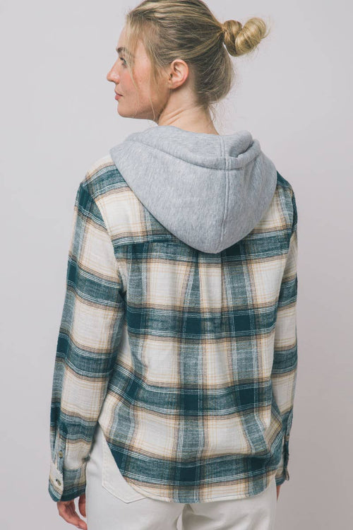 A woman shown from the back wearing a hooded long-sleeve plaid shirt. The shirt features a green, beige, and white plaid pattern with a light gray heathered hood.