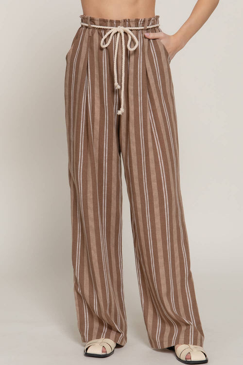 Brown and beige striped pants worn by a person on a plain background