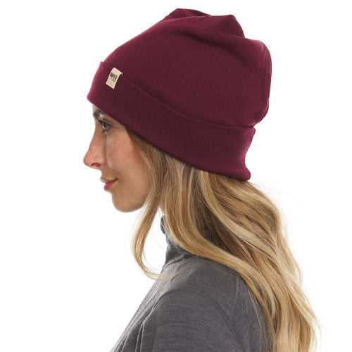 Woman wearing a maroon beanie on a white background