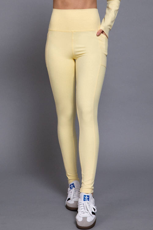 Yellow leggings worn by a person on a gray background
