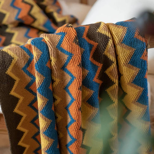 Close-up of a patterned fabric with zigzag design in brown, blue, and orange.