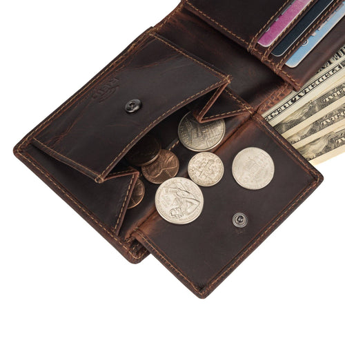 Open brown leather wallet with coins, bills, and cards on a white background