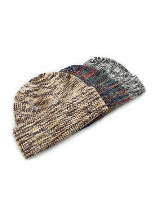 Three knit beanie hats overlapping on a white background. The front beanie is heathered in brown, beige, and gray tones, while the beanie behind it has a multicolor pattern with blue, red, and green threads on a dark base.